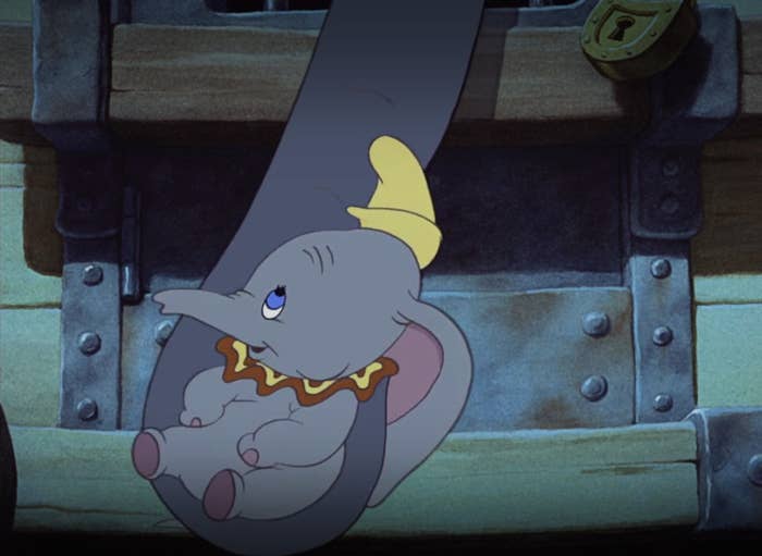 Jumbo cradles her baby in her trunk through the bars