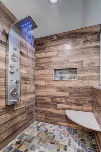 tiled shower with faux wood and the shower panel attached to the wall