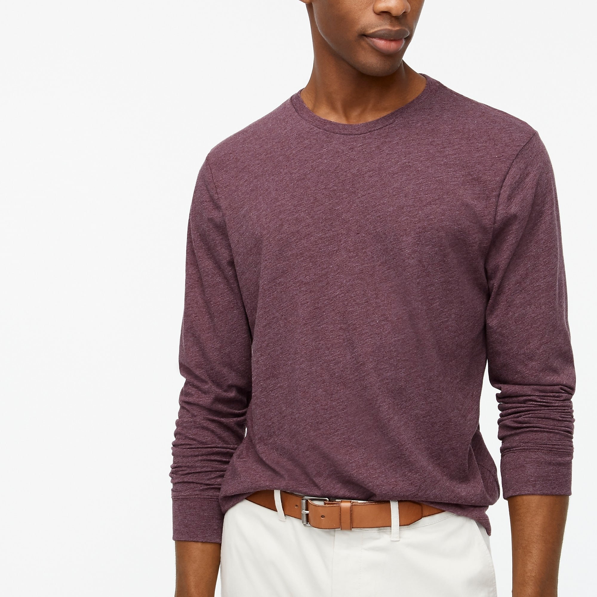 model wearing the tee in purple with white pants and a brown belt