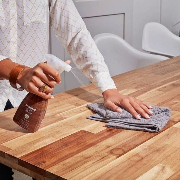 model cleaning a wood surface with the spray