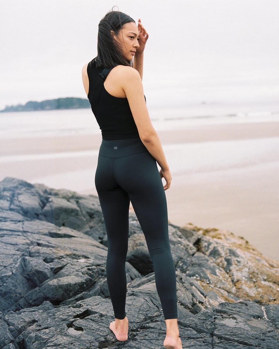 A person standing on a rock wearing the leggings with a tank top