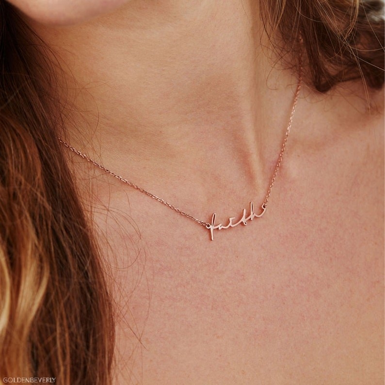model wearing the necklace that says &quot;faith&quot;