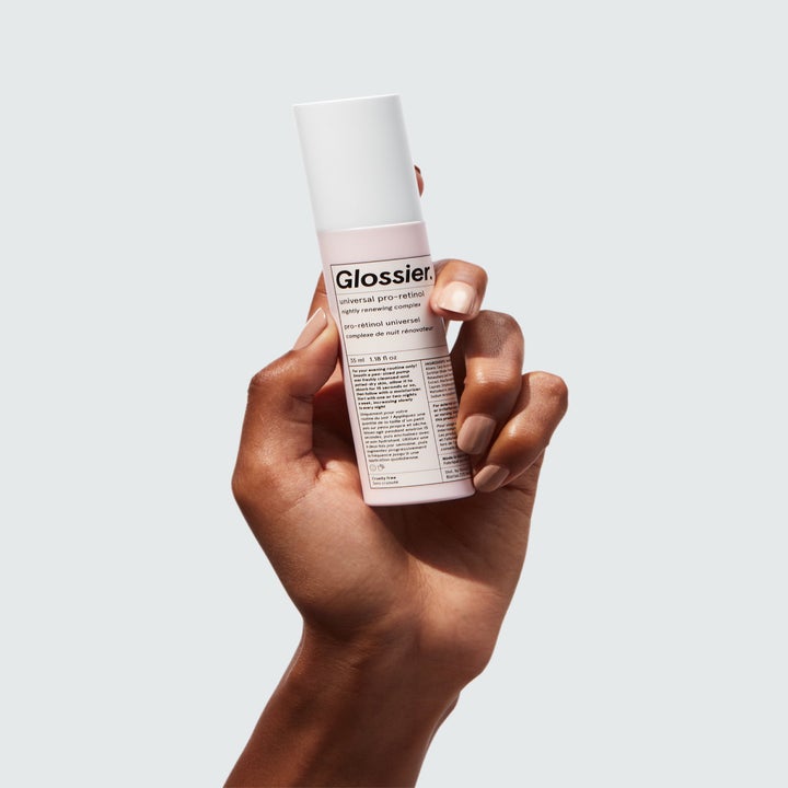 Model's hand holding the bottle of retinol