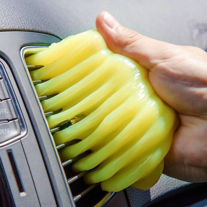 a model using the gel to clean a car air vent