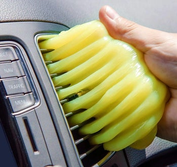 a model using the gel to clean a car air vent
