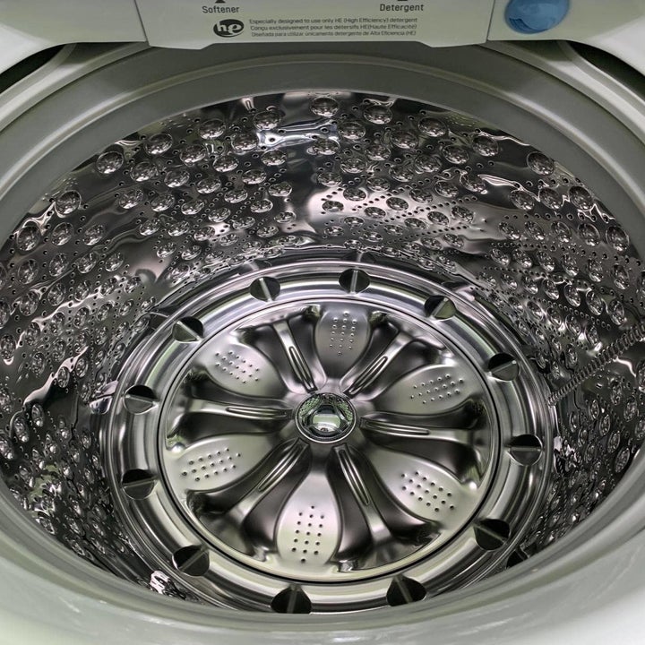 A reviewer photo of a shiny washing machine interior