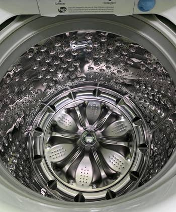 A reviewer photo of a shiny washing machine interior