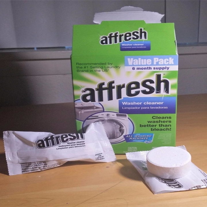 The Affresh Washing Machine Cleaner Tablets packaging next to an open tablet