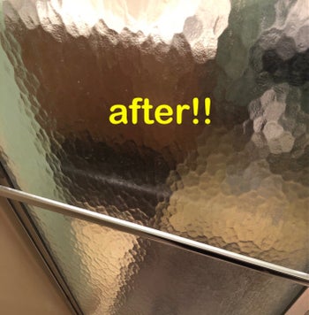 A reviewer's shower door after using the cleanser, completely clean and clear