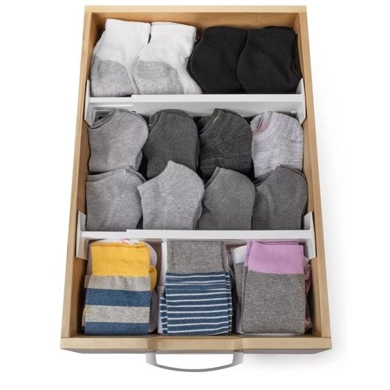 a drawer divided into three sections with the two expandable organizers