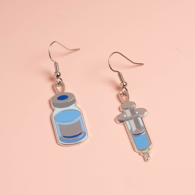 drop earrings, one shaped like a vial and one like a syringe