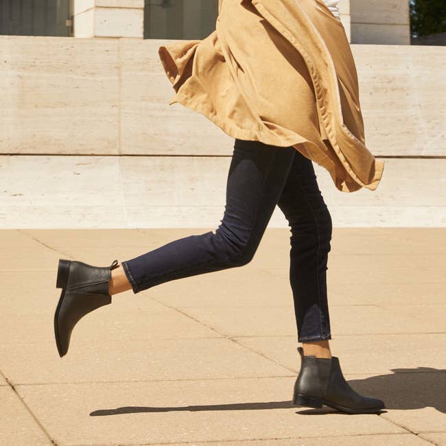 model in black Chelsea boots and skinny black pants