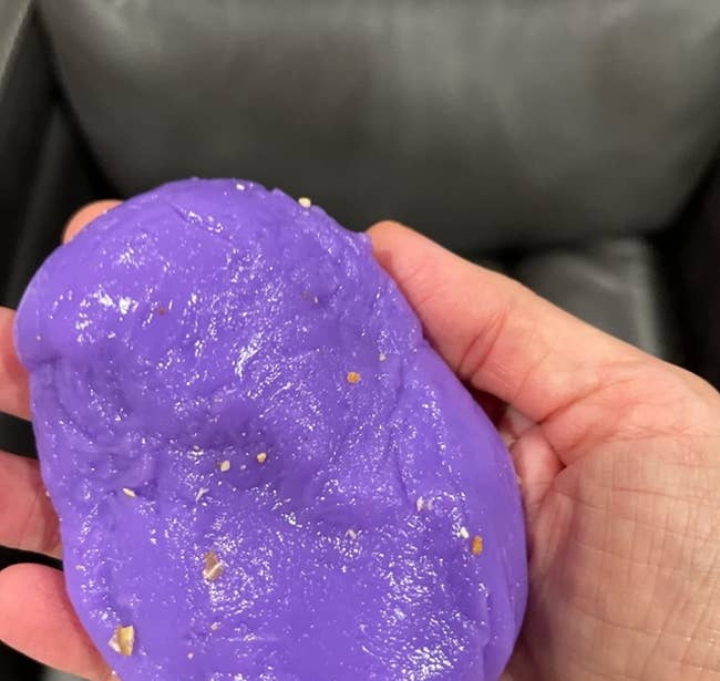 reviewer holding cleaning putty covered in crumbs
