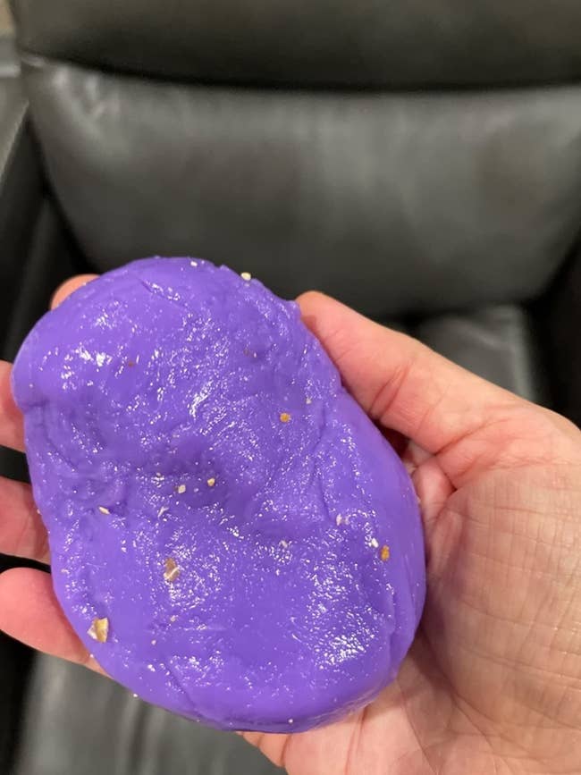 reviewer holding cleaning putty covered in crumbs