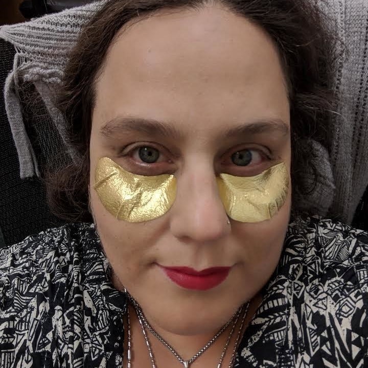 Reviewer wearing the gold under-eye masks