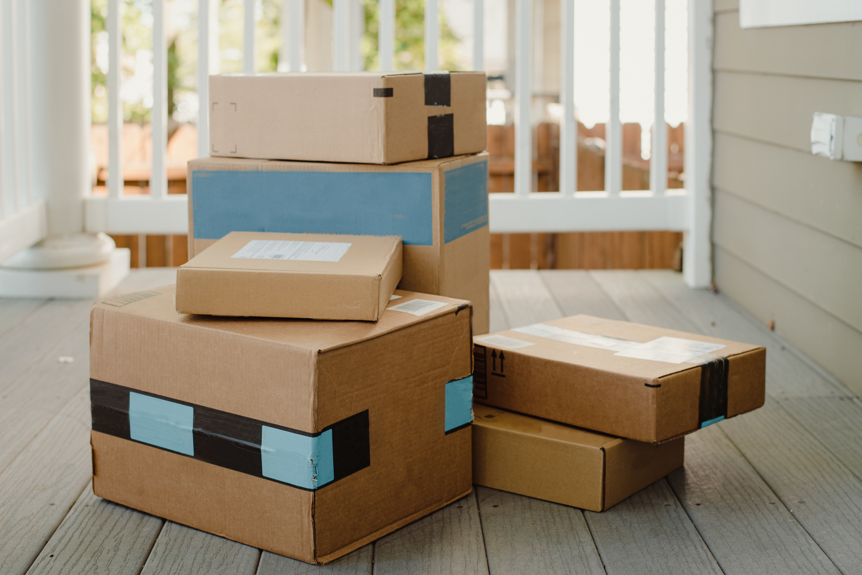 A big pile of packages from online shopping stacked up on a porch