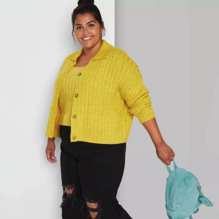 A model wearing the yellow cardigan open and styled with a matching yellow shirt