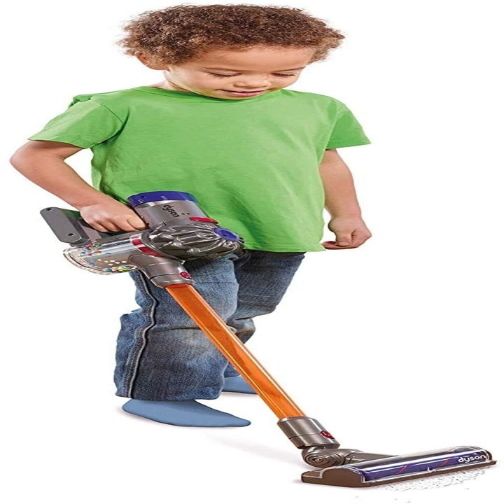 child using play dyson to vacuum