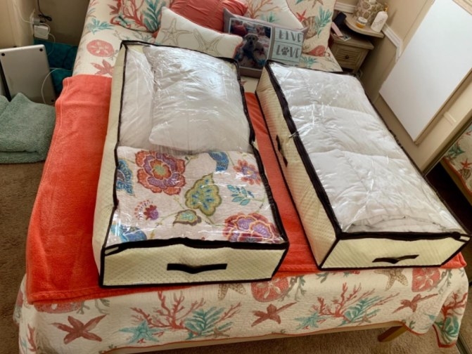 A reviewer's image of two foldable under bed bags used to store clothes