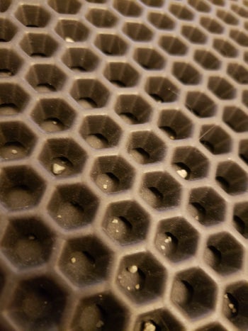 A close-up look at the litter trapped inside the mat's honeycomb design