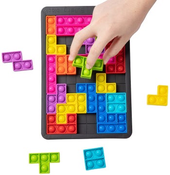 A hand placing a bubble piece in the tetris-like puzzle