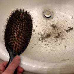 reviewer emptying lots of debri from same hairbrush