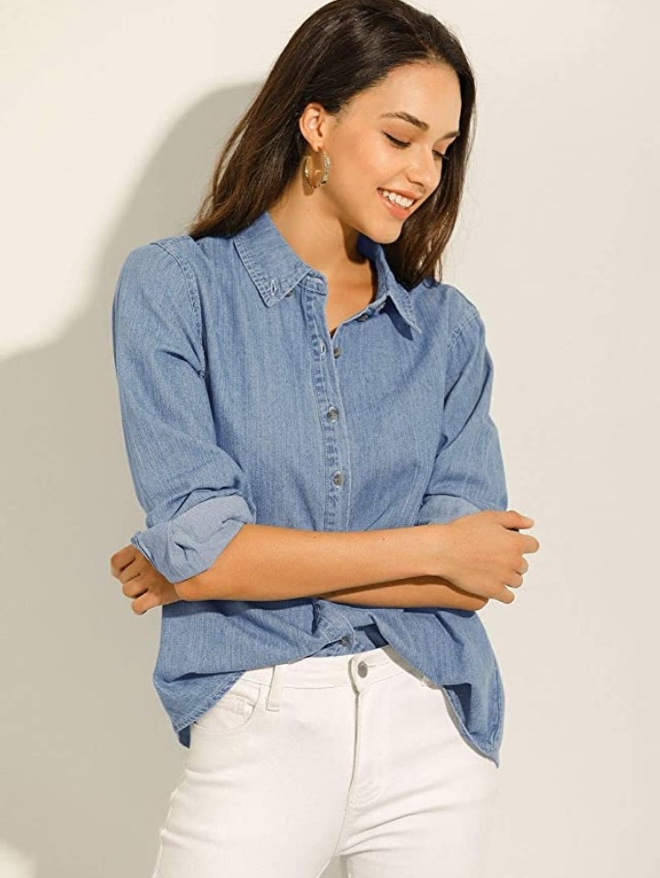 A model wearing a light blue denim button up shirt