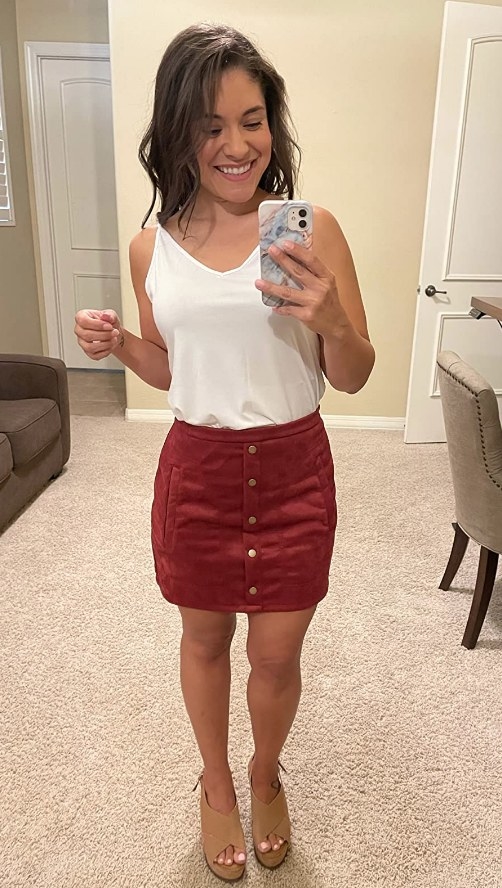 A reviewer wearing a wine colored suede skirt with front buttons