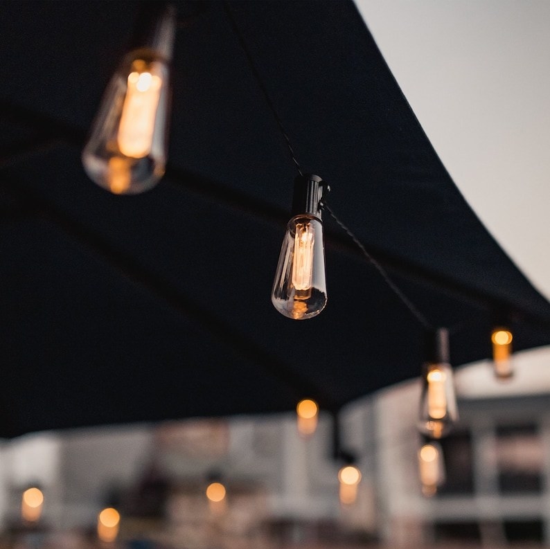 Product image of bulb string lights strung along a black umbrella