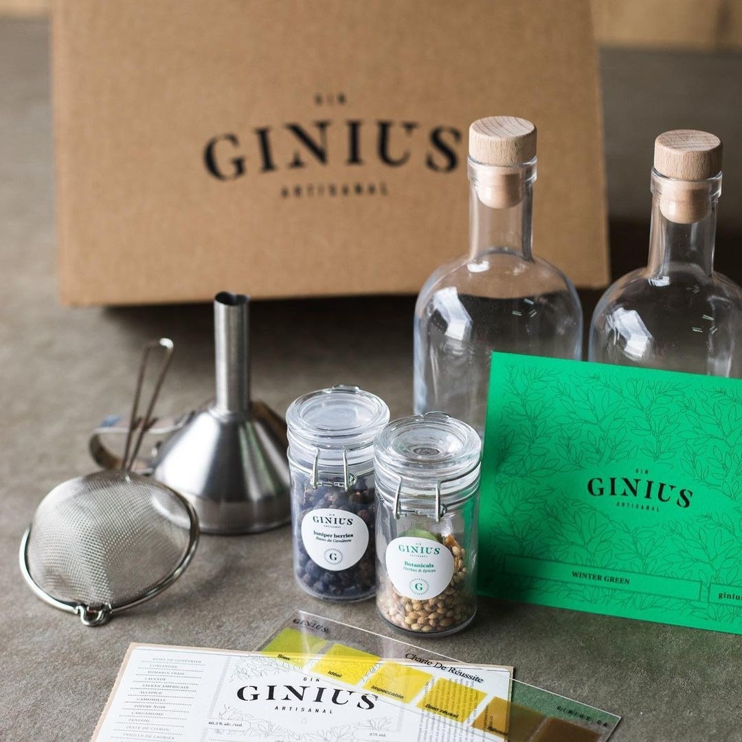 a gin-making kit with all the funnels, sieves, herbs, and spices laid out neatly on a counter