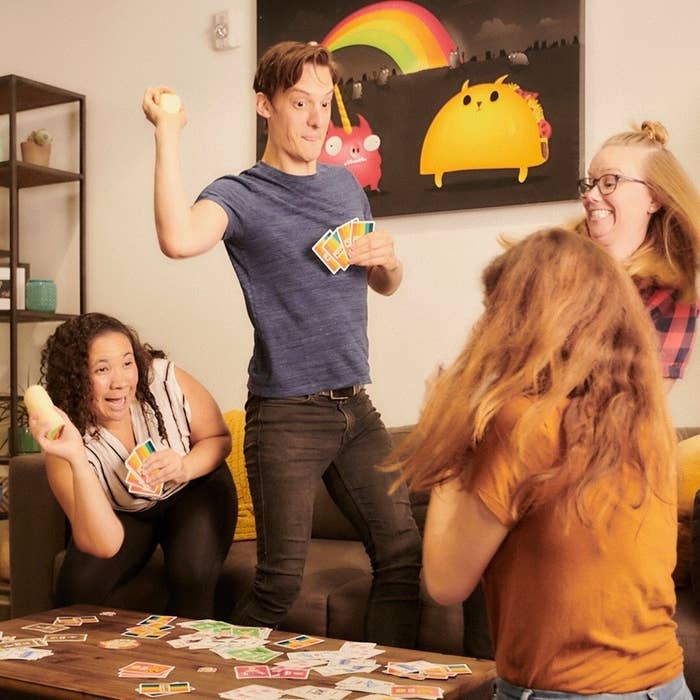 a group of friends playing the dodgeball card game; they are throwing soft burrito toys at one another