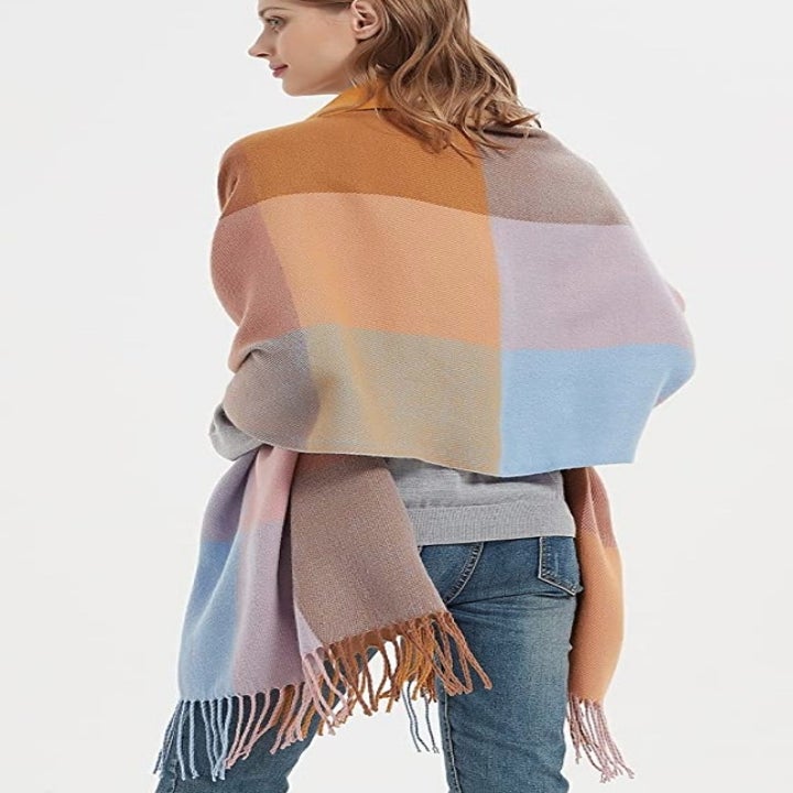 A model wearing a camel/blue/pink plaid scarf