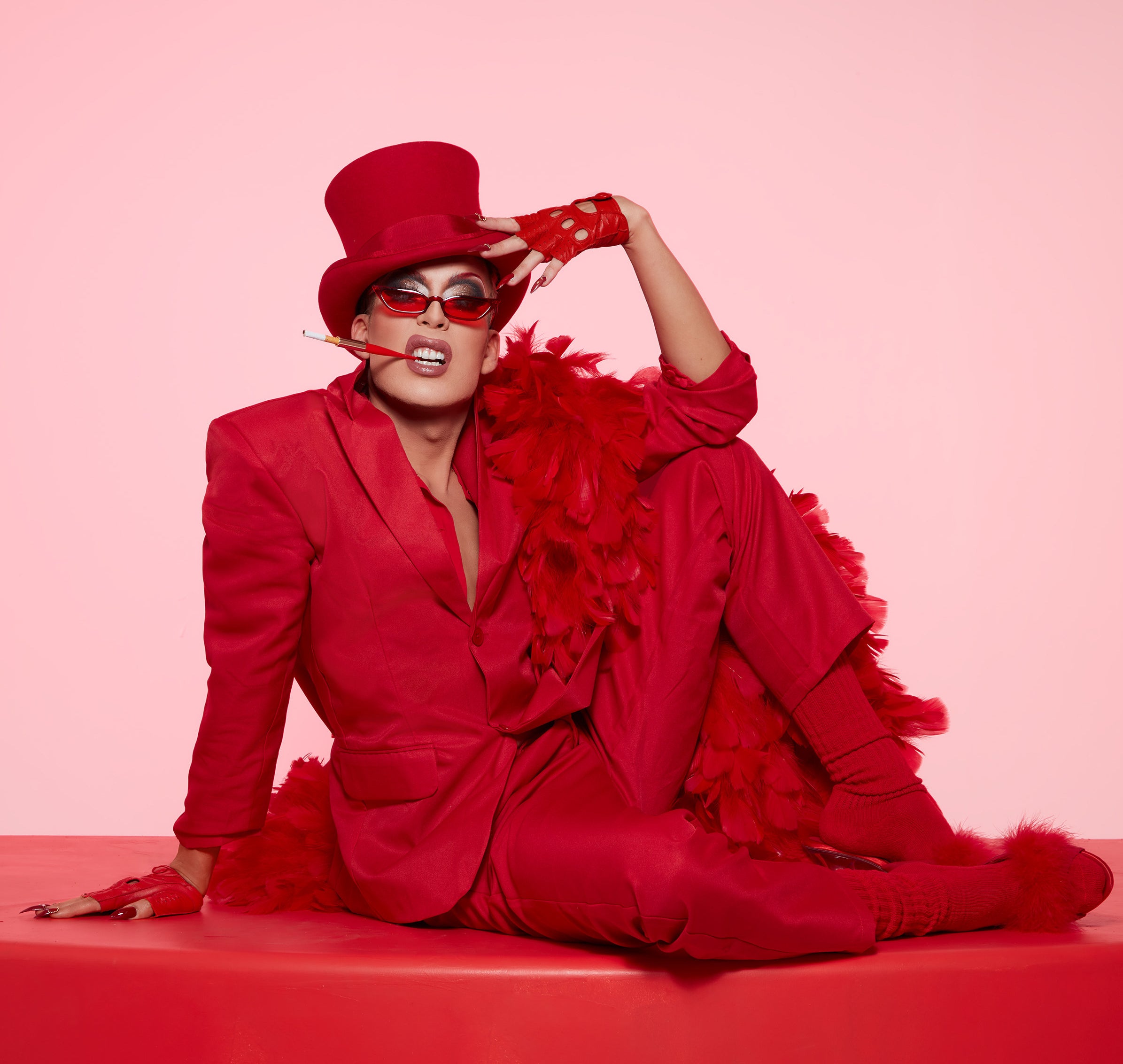 Alaska sitting on a red platform wearing a red suit and top hat