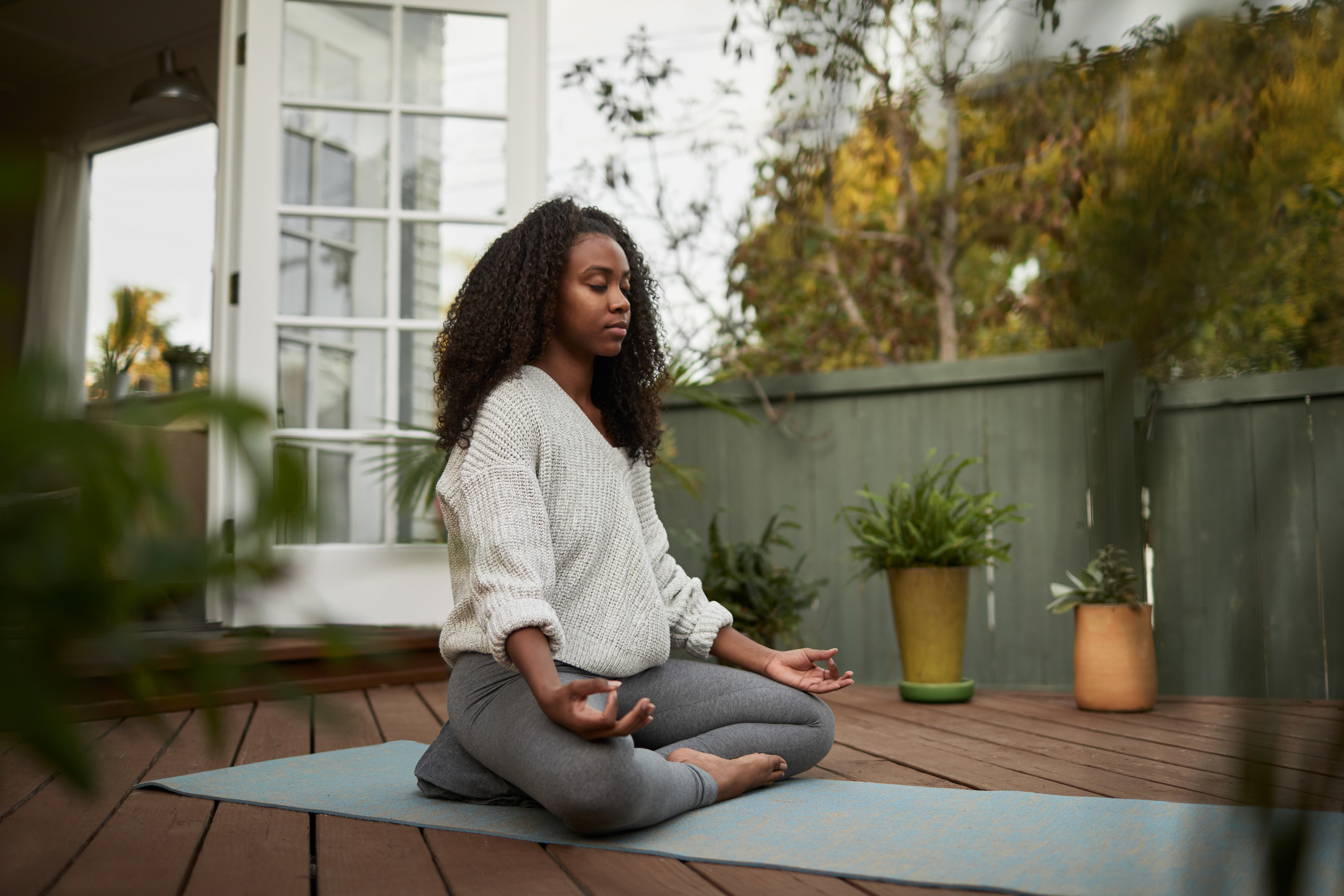 Woman meditating on her patio