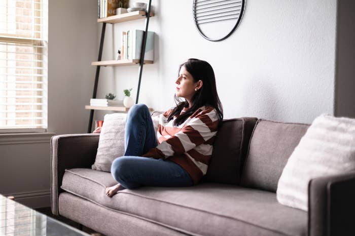 Person brooding on their couch at home