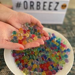 A reviewer holding up the water beads expanded in their hand