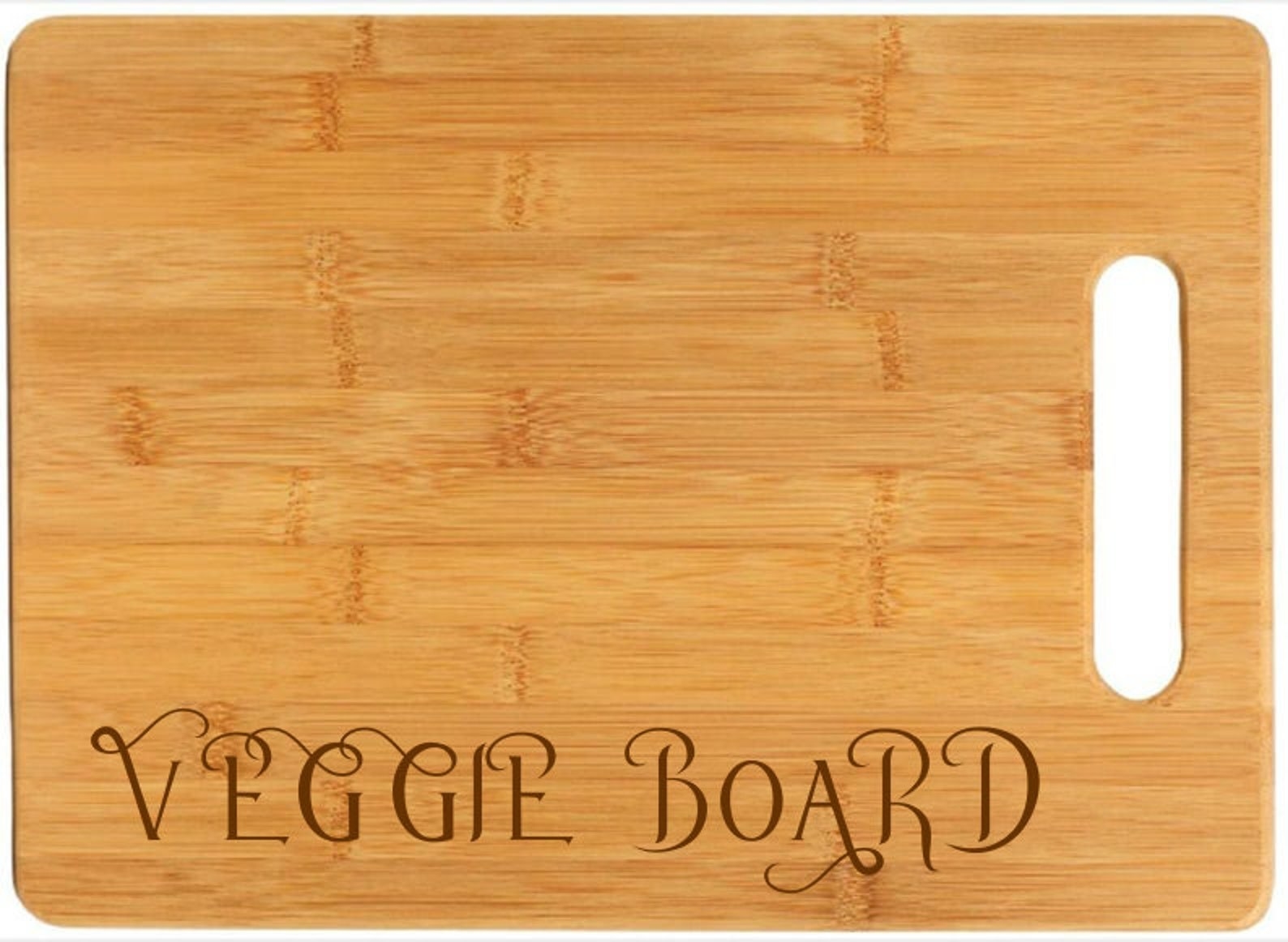 a cutting board with a handle that reads &quot;Veggie Board&quot; on one side