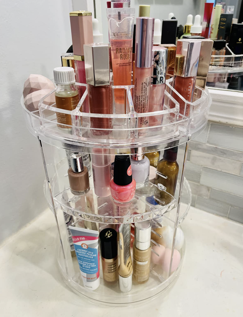 a reviewer photo of the three tired rotating shelf full of beauty products and toiletries