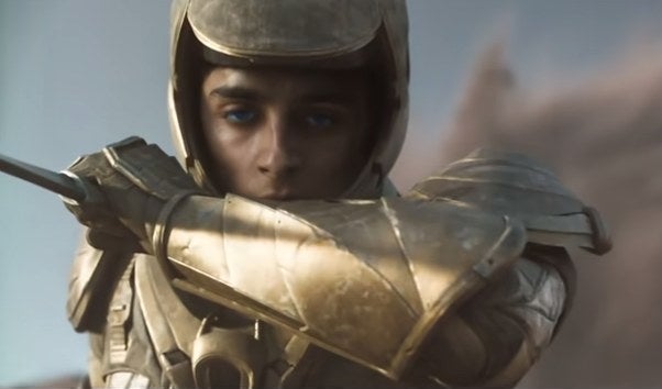 Paul with a knife, blue eyes, and golden armor in "Dune"