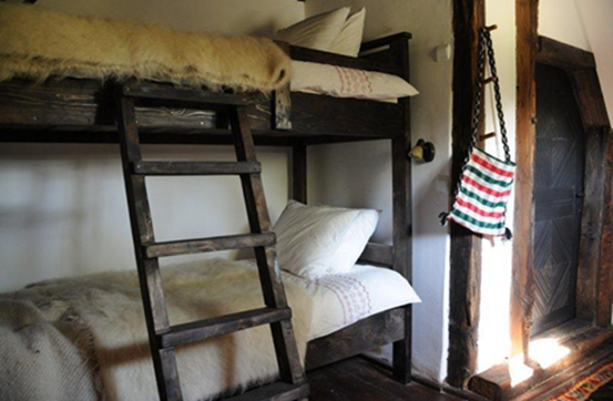 Two bunkbeds with old wooden ladder and fur blankets
