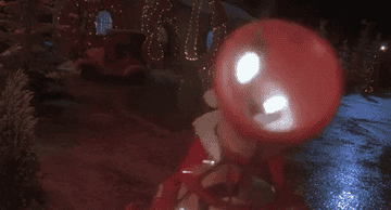 gif of character in santa outfit putting up holiday lights with a machine gun type tool
