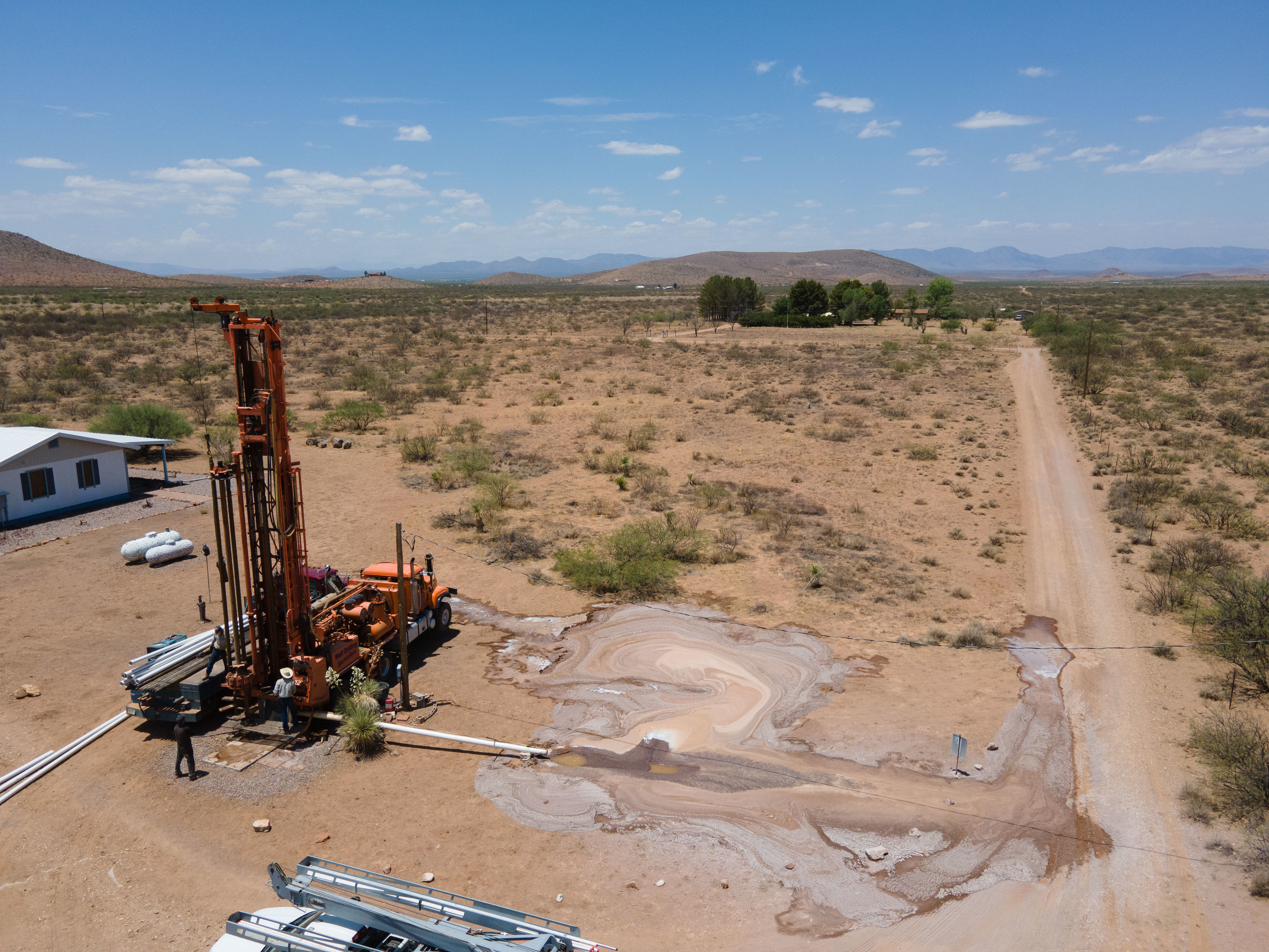 Water spills from heavy machinery in a dry desert landscape