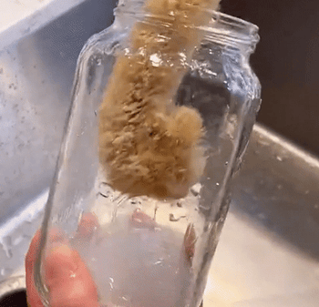 GIF of the brush being used to scrub a glass jar