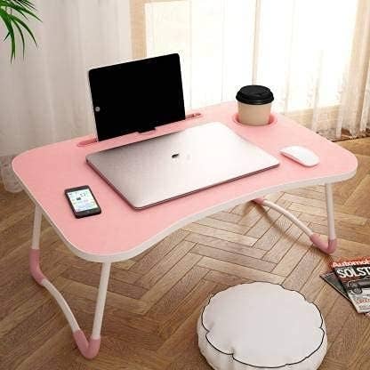 A folding table with multiple devices and a cup on it