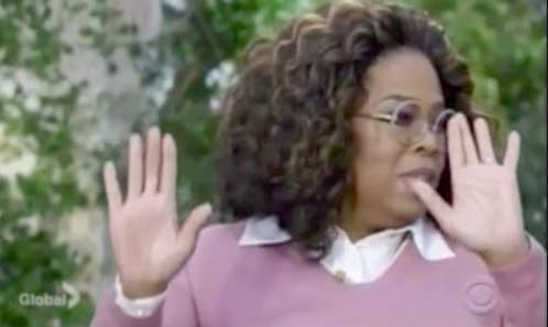 Oprah holding up her hands and looking to the side