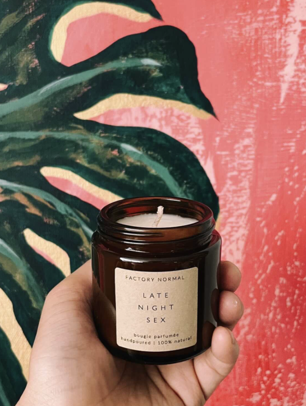 reviewer holding the amber candle in their hand. the label says late night sex.