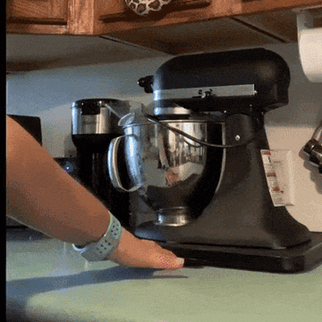 Gif of someone moving a black stand mixer freely on the counter with text on the gif that says &quot;look how easy this is to use even with two arthritic fingers&quot;