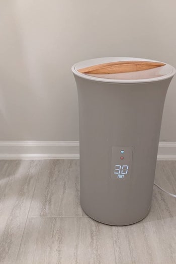 the minimalist column-shaped gray towel warmer, which has a wood lid