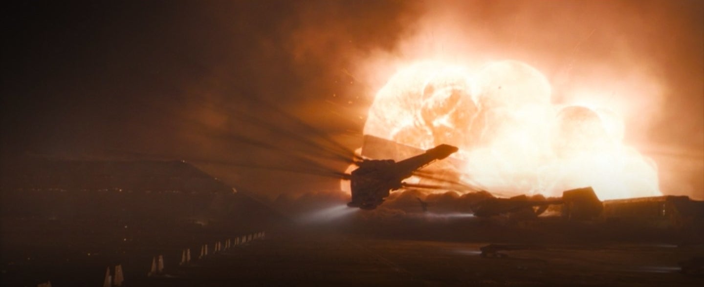 An ornithopter flying as an rocket explodes in the distance in &quot;Dune&quot;
