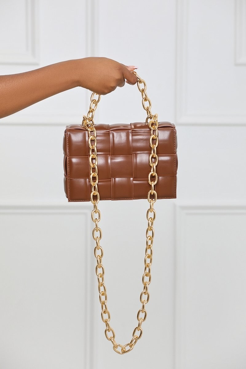 brown rectangular woven bag with gold hand and shoulder chains